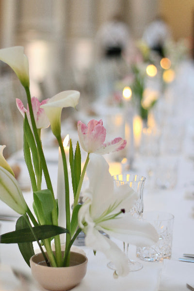 PInk tulips with white calla lilies in a small ceramic bowl
